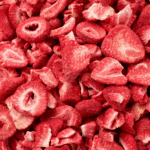 A close-up of freeze-dried strawberry slices in vibrant red color.